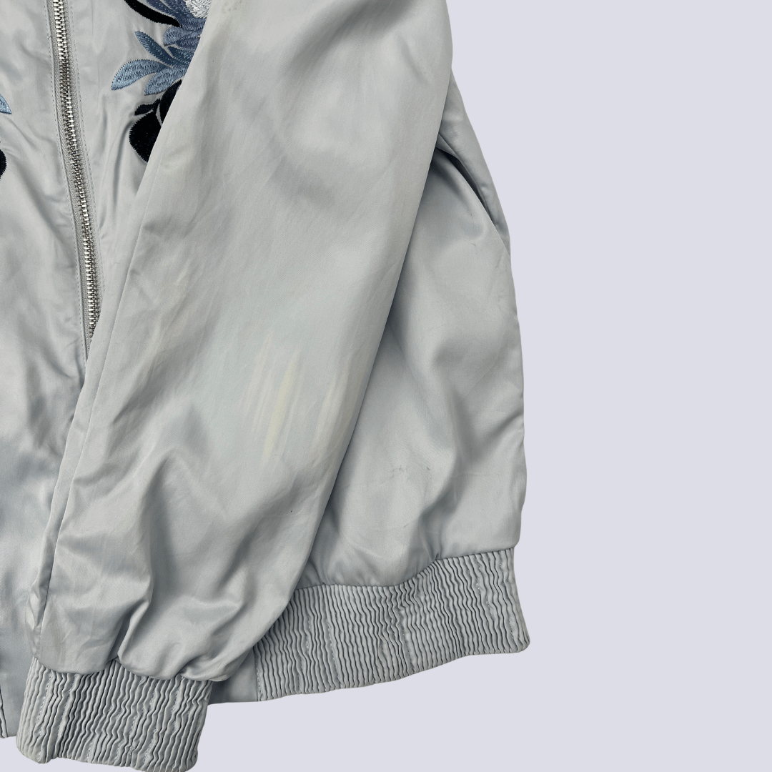 Front hem detal view of the baby blue satin bomber jacket