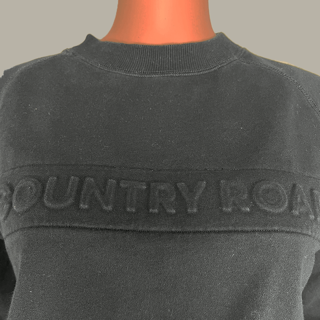Detail view of the logo on the Country Road Heritage Black Sweat
