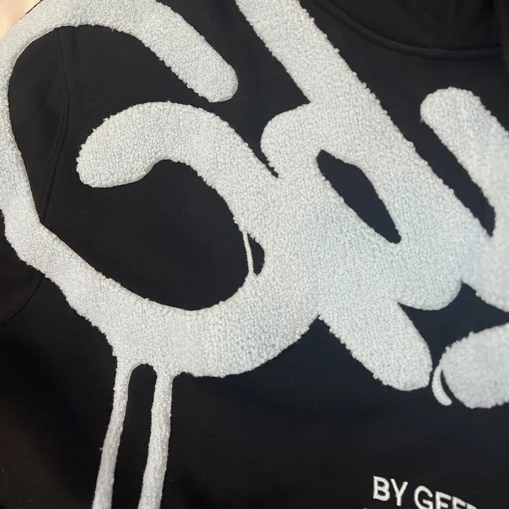 Logo Detail View of the Geedup Co Handstyle Hoodie | Black/Baby Blue