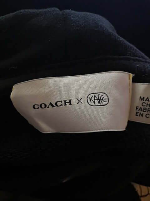 Tag detail of the Coach Rexy the Dinosaur Black Hoodie
