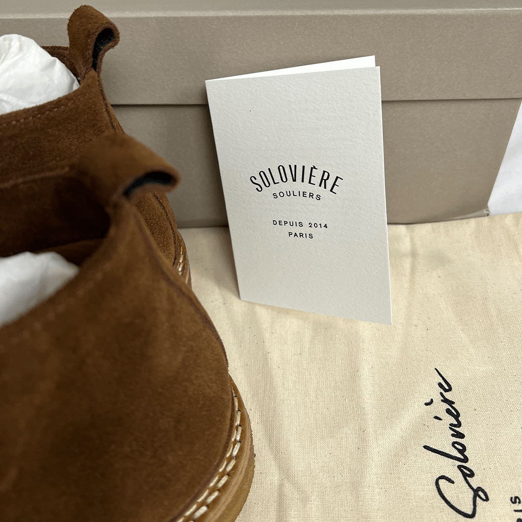 Detail view of the box and booklet of the Jacques Soloviere Oliboot Suede Boot