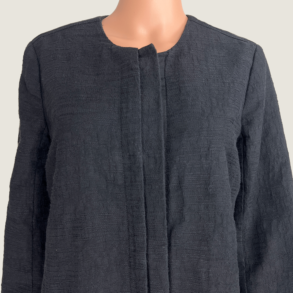 Front collar close up view of the Verge black collarless overcoat