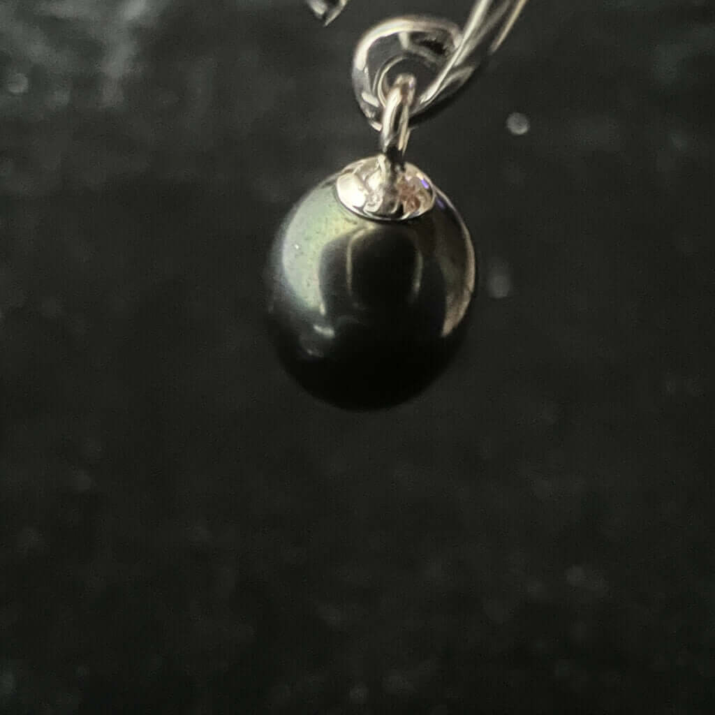 One black pearl drop earrings close up