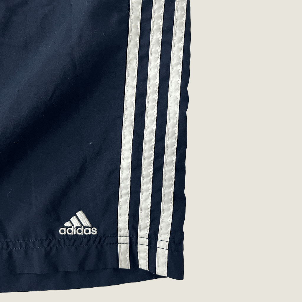 Front hem detail of the Adidas men's Essentials Chelsea 3-stripe shorts