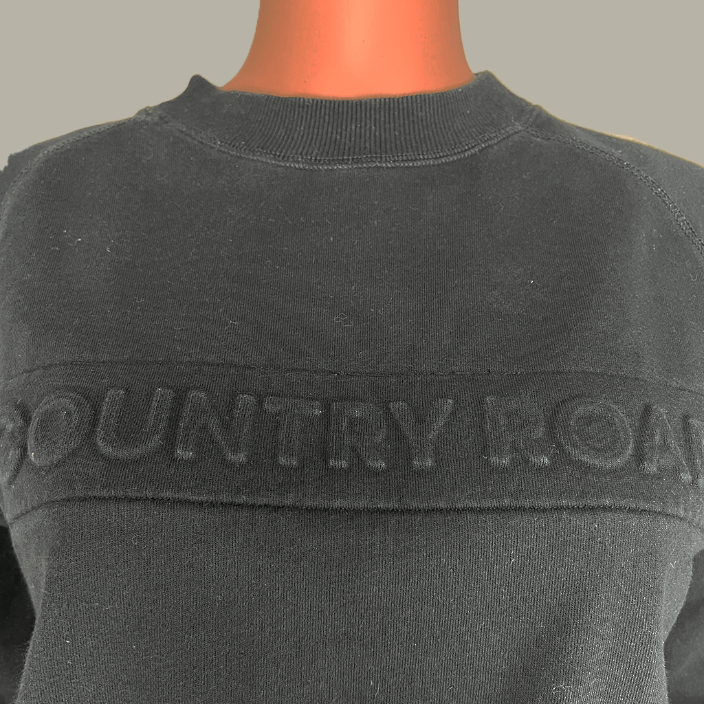 Detail view of the logo on the Country Road Heritage Black Sweat