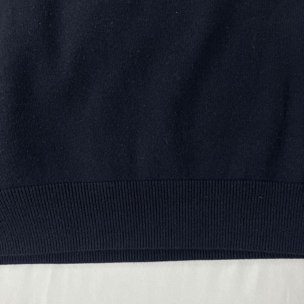 Front hem detail of the Fred Perry black classic knit top