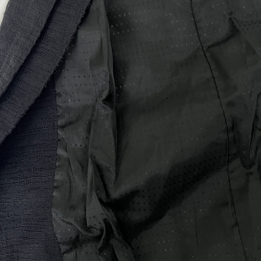 Inner view of the Verge black collarless overcoat