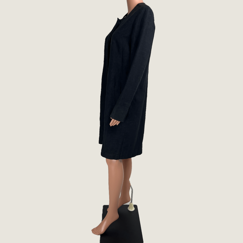 Side view of the Verge black collarless overcoat