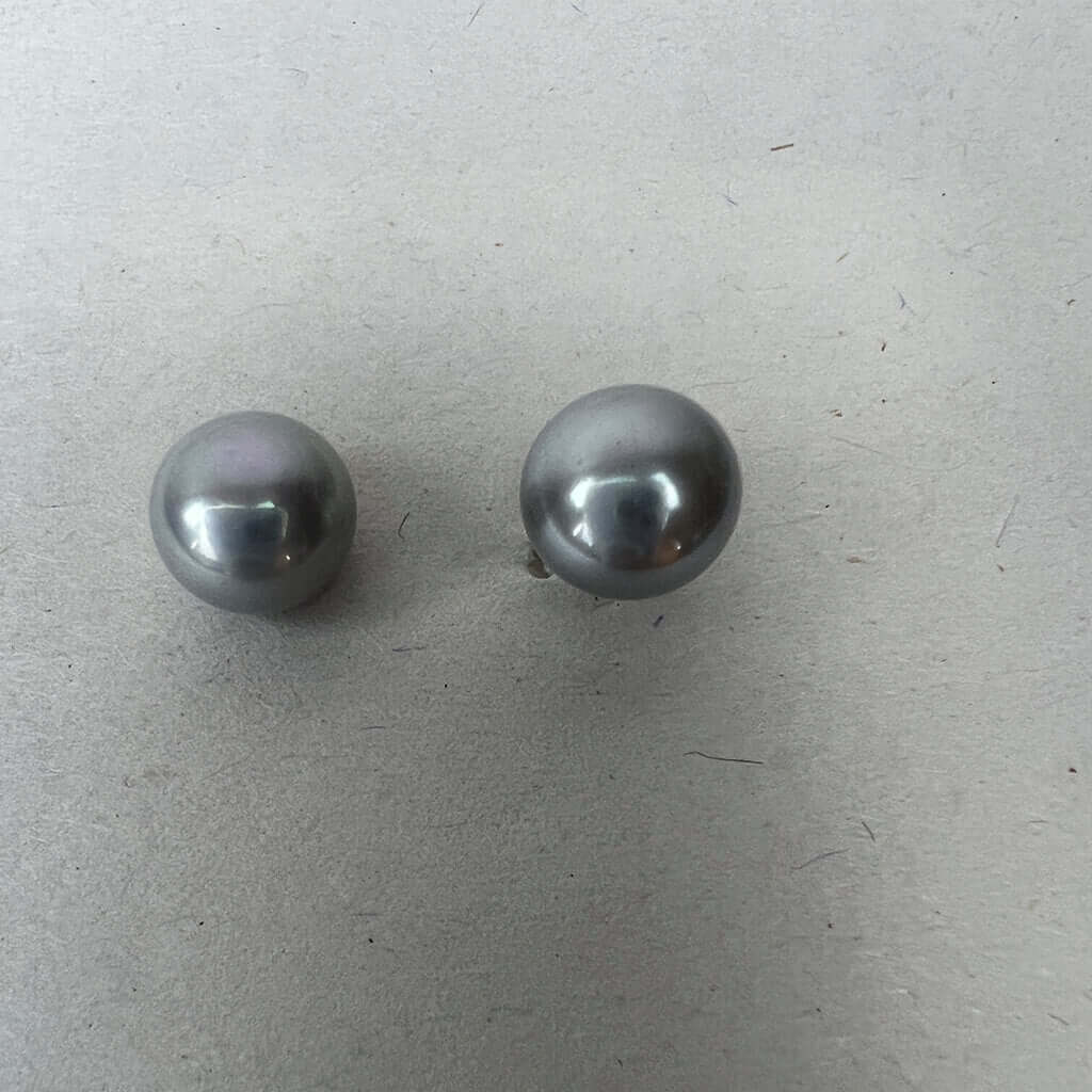Grey pearl stud earring pair on white background