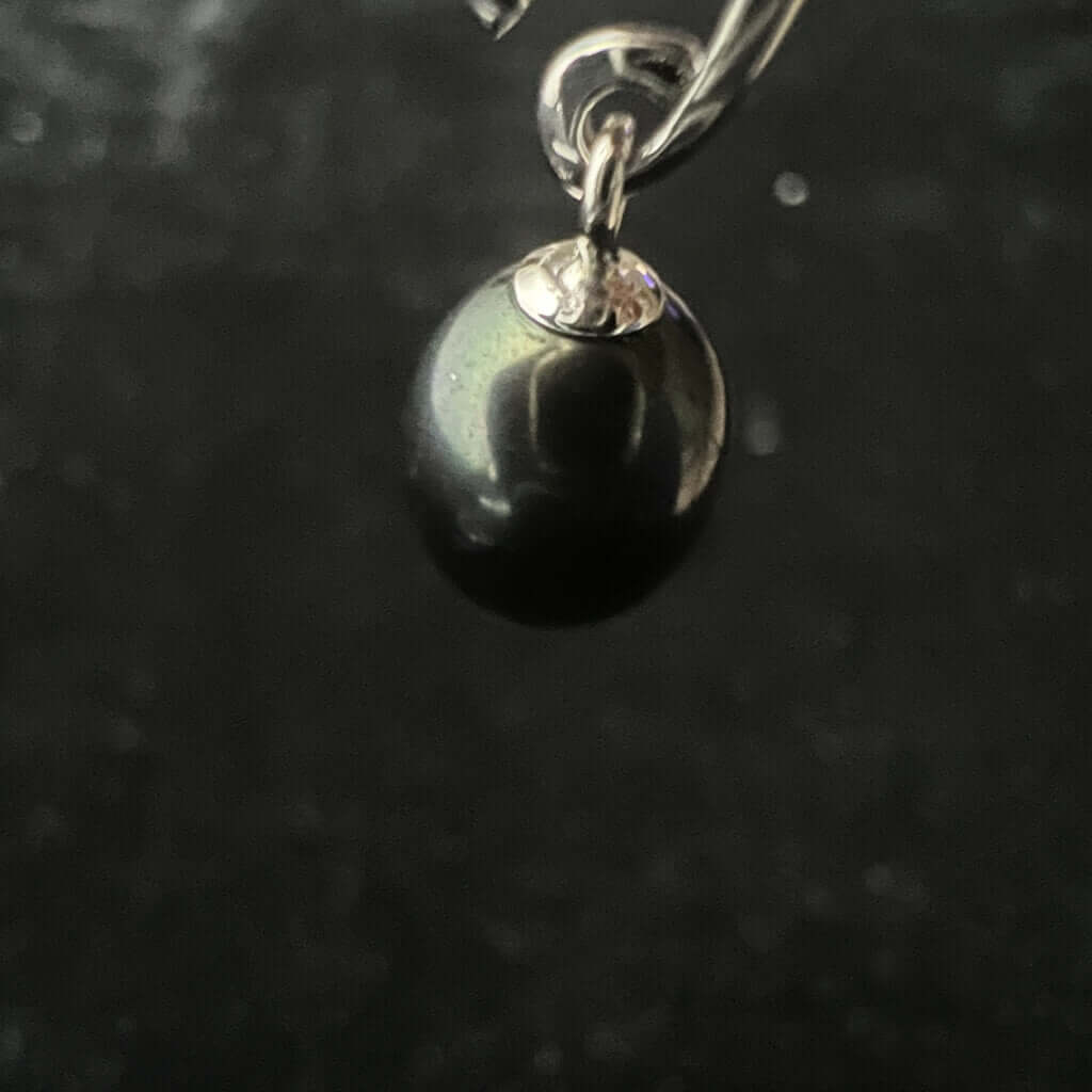 One black pearl drop earrings close up 